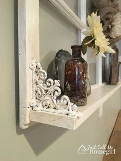 an old window frame is holding vases and flowers on a shelf in the corner