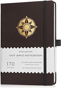 a brown notebook with a gold compass on the front and white border around the cover