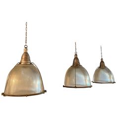 three light fixtures hanging from chains on a white background