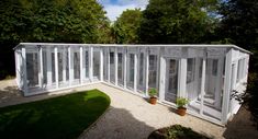 a white building sitting in the middle of a lush green park