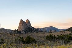 the mountains are covered with trees and bushes at sunset or dawn in the desert area