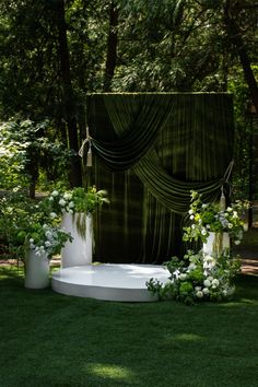 an outdoor ceremony setup with white flowers and greenery