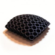 a black decorative pillow sitting on top of a white table