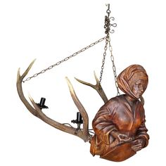 a sculpture of a person sitting on a deer's head with two antlers attached to it