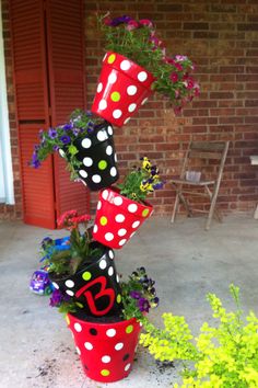 a red and black polka dot pot with flowers in it