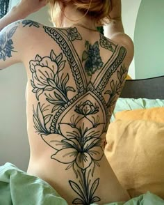 the back of a woman's body with tattoos on it