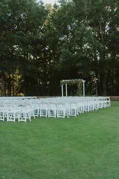 rows of white folding chairs set up for an outdoor ceremony