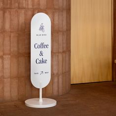 there is a sign that says coffee and cake next to a wall with a bike on it