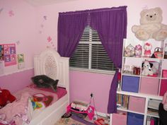 a child's bedroom with pink walls and purple curtains