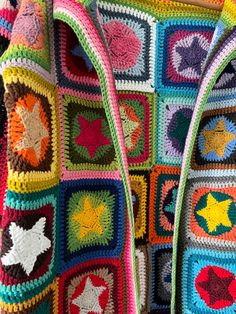 a multicolored crocheted bag hanging on a wall