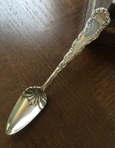 a silver spoon sitting on top of a wooden table