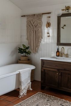 a bathroom with a sink, bathtub and rug on the floor in front of it