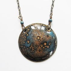 a necklace that has some kind of blue and brown object on it's chain