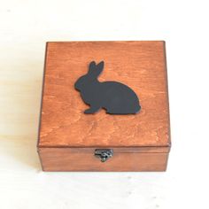 a small wooden box with a black rabbit on it