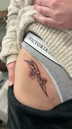 a woman with a flower tattoo on her stomach and the word victoria written in black ink