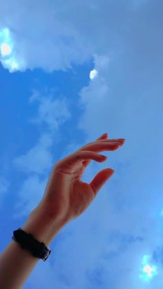 a person's hand reaching up into the sky