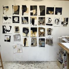 an art studio with various pieces of artwork hanging on the wall