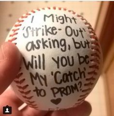 a hand holding a baseball with words written on it