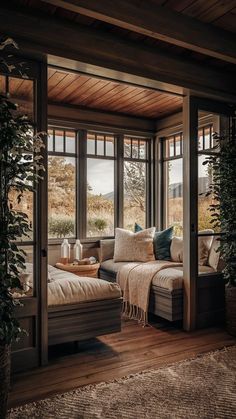 a living room filled with lots of windows next to a couch and rug on top of a hard wood floor