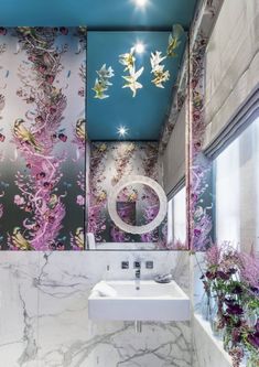 the bathroom is decorated with pink flowers and blue ceiling tiles, along with a white sink