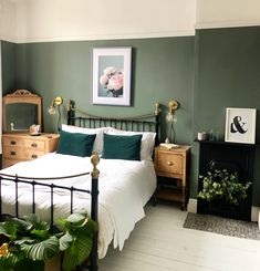 a bedroom with green walls and white bedding