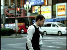 a man is walking down the street while talking on his cell phone