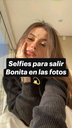 a woman sitting in front of a window with her hand on her face and the words selfies para salir bonita en las fotos