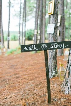 a wooden sign that says walk our story in front of some trees with pictures on it