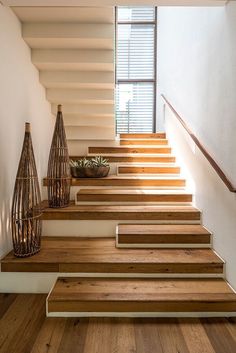 a set of wooden steps leading up to a window in a white room with wood flooring