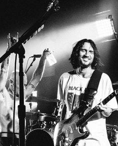 two men on stage with guitars and microphones