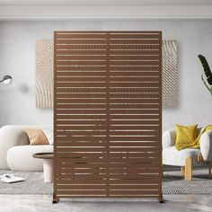 a living room with white couches and wooden slatted screens on the wall