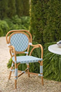 a blue and white chair sitting next to a table with a plate on top of it