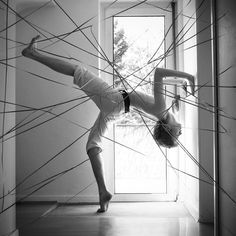 a woman standing on one leg in front of a door with lines drawn all over her body