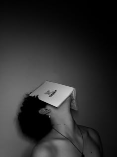 a woman wearing a paper hat with her head in the shape of a book on top of her head