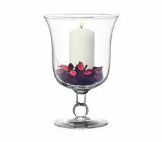 a glass candle holder with flowers in it