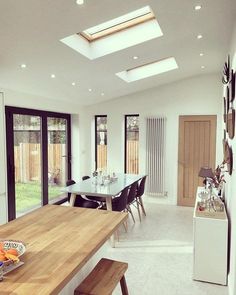 a dining room table with chairs and a skylight