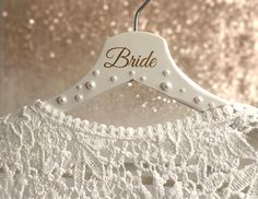 a wedding dress hanger with the word bride on it