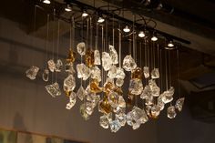 a chandelier hanging from the ceiling with many different colored glass pieces on it