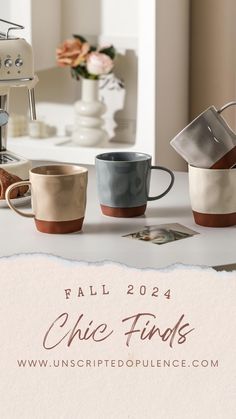 four coffee cups sitting on top of a counter next to an espresso machine