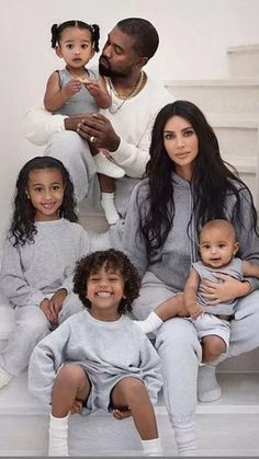 the family is posing for a photo in their matching grey tracksuits and white sneakers