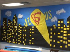 a bulletin board with a superman theme in the middle and some pencils on top