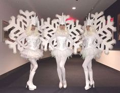 two women dressed in white are standing next to each other with snowflakes on them