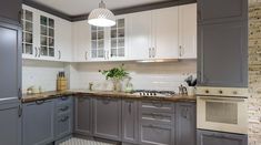 a kitchen with gray cabinets and white appliances