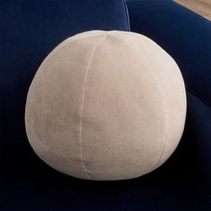 a round pillow sitting on top of a blue chair