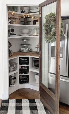 an open pantry door in the corner of a room with black and white checkered rug