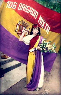 a woman is holding a large flag in front of her and posing for the camera