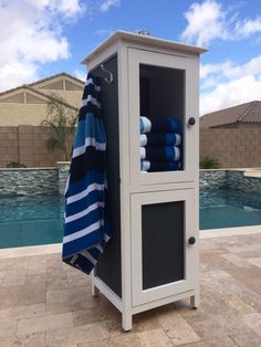 a cabinet with towels on it next to a pool