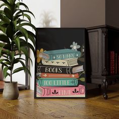 a stack of books sitting on top of a wooden table next to a potted plant