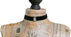 a mannequin with sheet music on it's neck and black ribbon around the neck