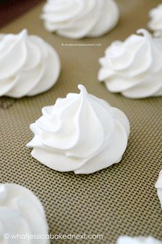 white frosted cupcakes sitting on top of a cookie sheet